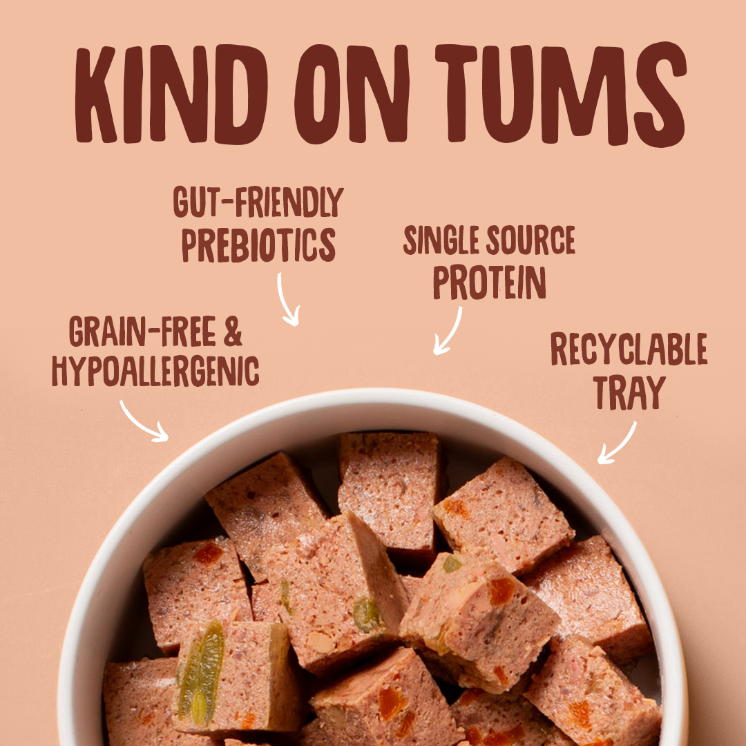 Bowl of pet food with 'Kind on Tums' text highlighting features like gut-friendly prebiotics, single source protein, grain-free & hypoallergenic, recyclable tray.
